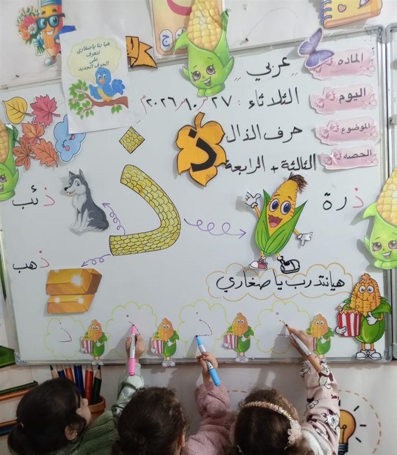 أطفال الروضة يتدرّبون على كتابة حرف الذال على اللوح