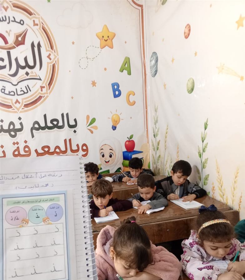أطفال الروضة يكتبون أشكال حرف الذال في دفاترهم